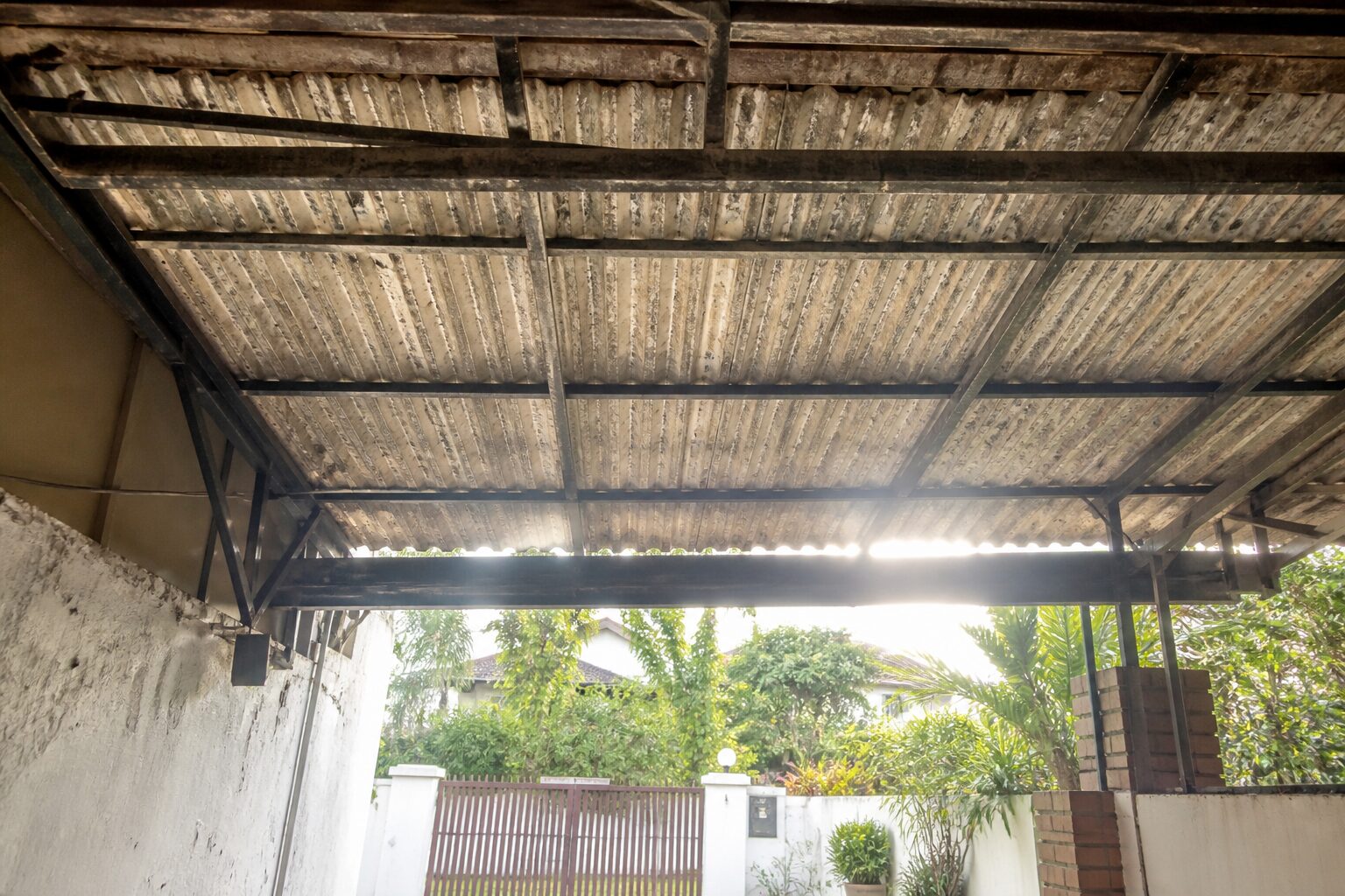 A car porch roofed with old corrugated zinc sheeting